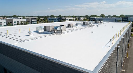 Restored white silicone commercial roof coating after